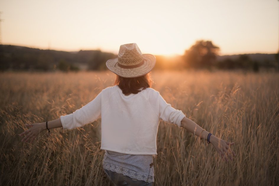 Femme se promenant dans un champ - l'image symbolise le concept de se libérer pour inspirer et les raisons derrière ce blog